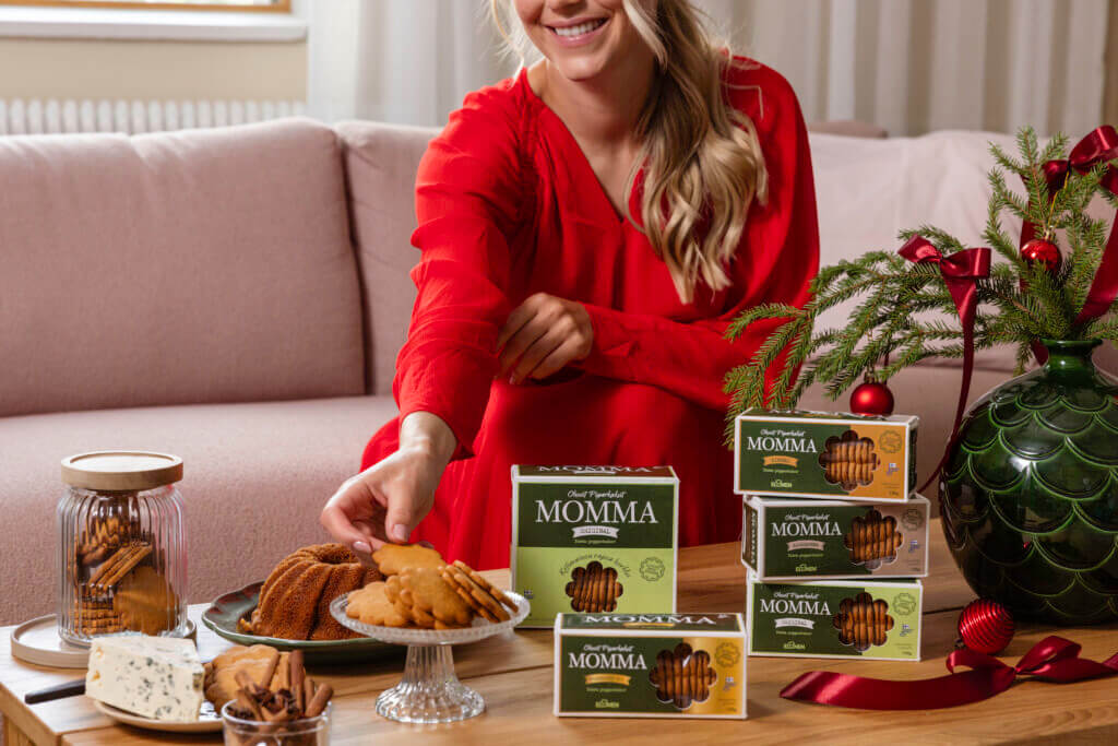 Nainen nauttii Elosen Momma -pipareista ja jouluisista herkuista kotisohvalla.