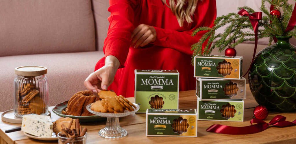 Nainen nauttii Elosen Momma -pipareista ja jouluisista herkuista kotisohvalla.